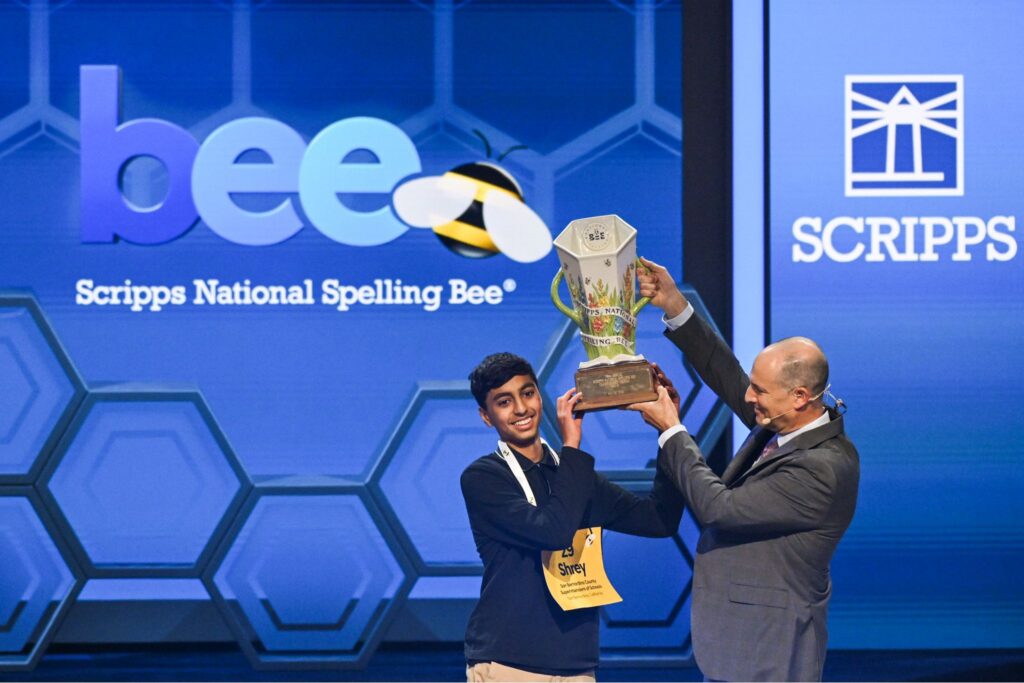 2026 Scripps National Spelling Bee Champion Shrey Parikh holds the Scripps Cup with Adam Symson, President & CEO of The E.W. Scripps Company